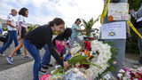 A group of Poway residents bring flowers and cards to a memorial outside of the Chabad of Poway synagogue, Sunday, April 28, 2019, in Poway, Calif. A man opened fire Saturday inside the synagogue near San Diego on the last day of Passover.